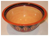 A Bali stoneware wide bowl, decorated with diamond shape geomatric design and glazed with red and black unerglazes on peach background - third view.